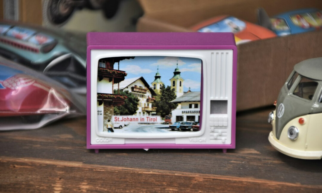 Vieux téléviseur diffusant une publicité vintage dans un salon suisse